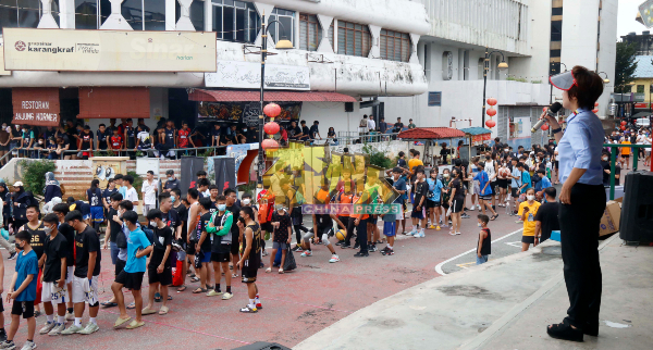 陈丽群向参加篮球赛的年轻人介绍芙蓉文化街。