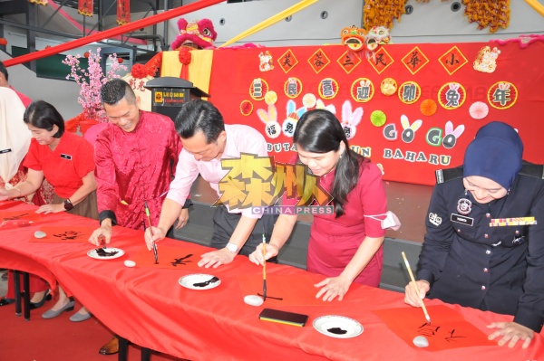 温文凤（左起）、甘信荣、谢琪清、刘秀美和尤斯妮达一同挥春写下福字。 