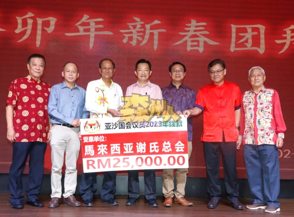 谢琪清（左4）移交2万5000令吉支票予马来西亚谢氏总会，左起谢华隆、谢耕伟、谢炎本，右起谢家楼、谢江发及谢崇岳。