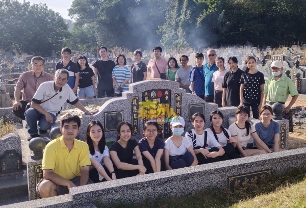 启智校友会主席萧馼庆（后排左）偕同家庭成员祭拜先母，在墓前合照留念。