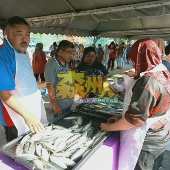 罗斯里（左2）巡视鱼摊，居民有秩序的排队购物。