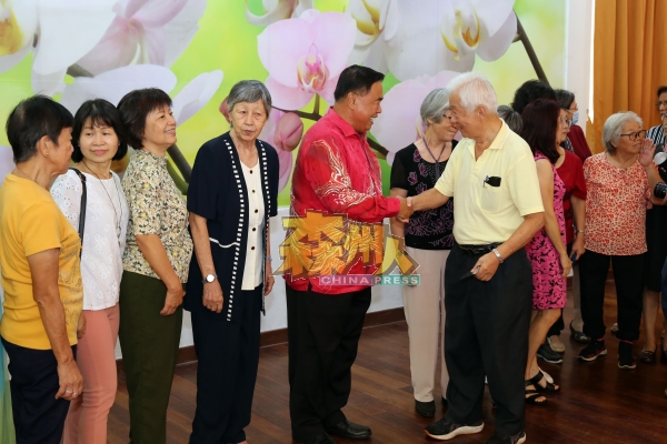 胡国钦（左5）与每位出席的退休教师握手问好。