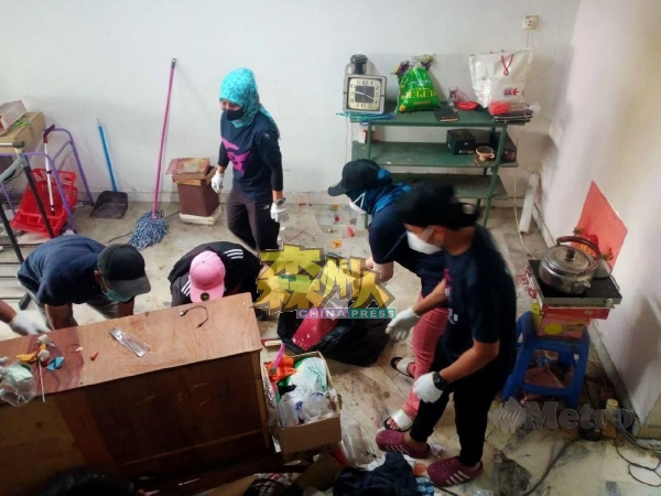 非政府组织协助一名华裔老妇打扫及清理房屋单位内堆积的垃圾。（照片取自Harian Metro）