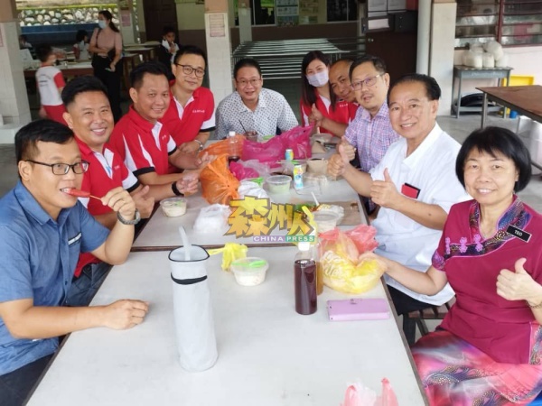 芙蓉新华小学三机构理事会成员，一同享用在义卖会买来的美食；右起是张美蓉和吴泉有。