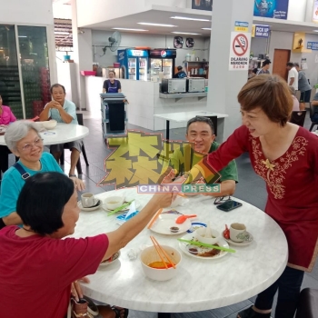 ：陈丽群（右）在芙蓉新城美食中心，与民众握手表达谢意。