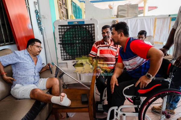 莫哈末再迪（右）坐者轮椅，到遮兰巴当州选区向选民拜票。