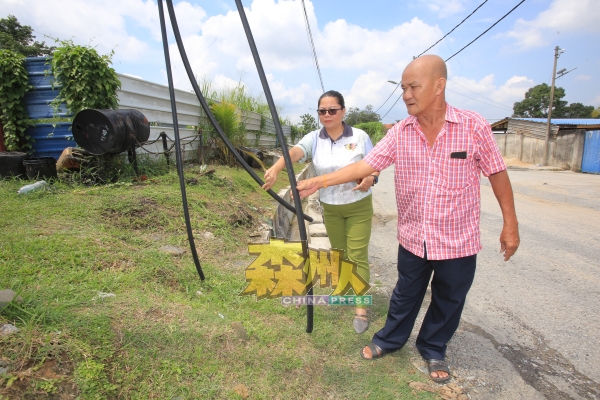 苏丽（左起）和刘天财巡视其中一段被剪断的电缆。
