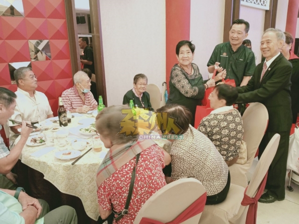 陈怀国（后排右起）、谢琪清趁着孝亲敬老晚宴，到台下赠送礼品予会馆年长乡贤。
