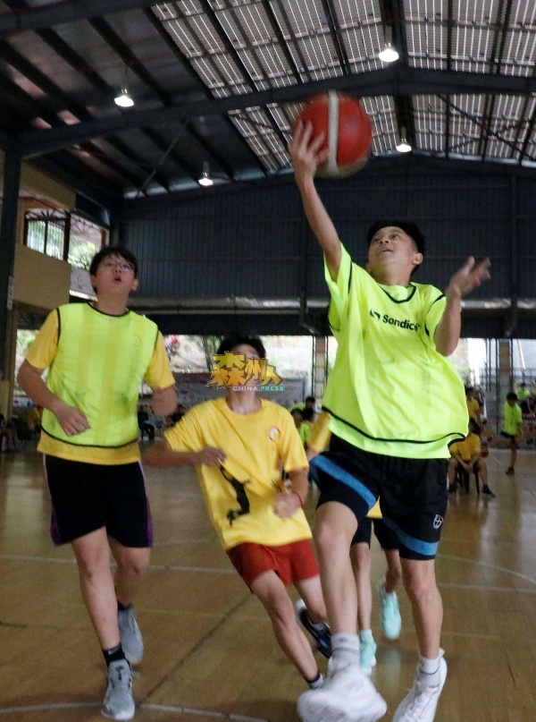 ：在“三人篮球赛黄氏杯”的赛事中，参赛球员施展浑身解数，以便为队伍争取分数。