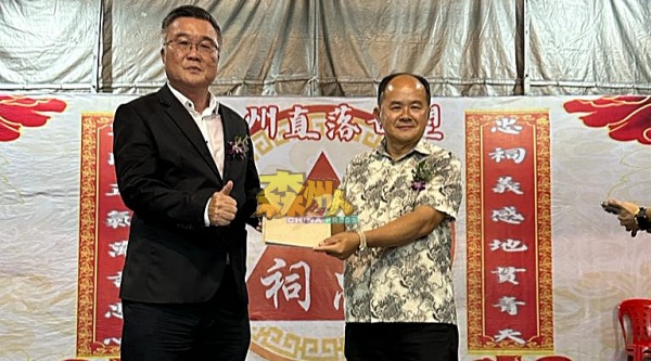 卓鸿宽（右）移交1000令吉波中教育基金给卓鸿春（左）。
