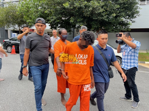 两名男嫌犯（穿橙色囚衣者）被警员带上芙蓉推事庭申请延长扣留。