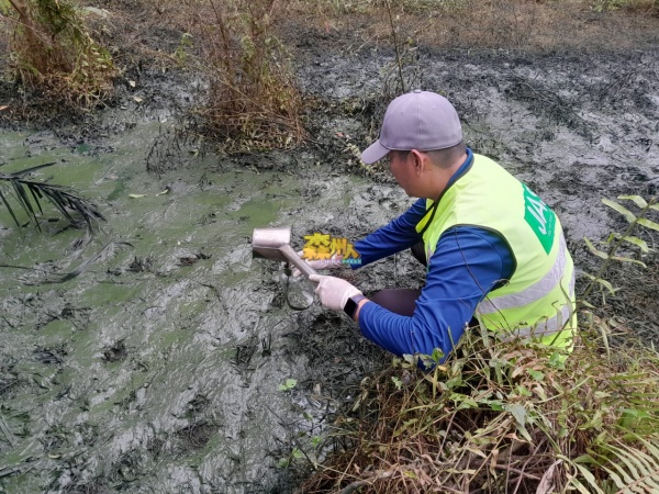 森州环境局官员小心翼翼的收集有毒废料液体样本。