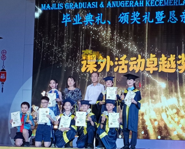 获得课外活动卓越奖的学生，与嘉宾合摄；后排左2起温芝琳及黄国强。
