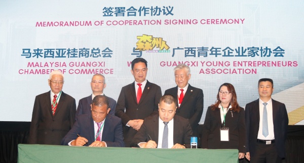 陈拔钊（前排左起）与莫吕斌代表马来西亚桂商总会与广西青年企业家协会签署合作协议；后排左起是黄思华、吕海庭、张聒翔、卢成全、梁小琴和龙其生。