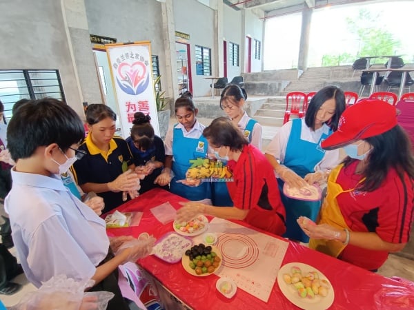 学生包括友族学生专注跟随导师的指示，一步步完成冰皮月饼制作。