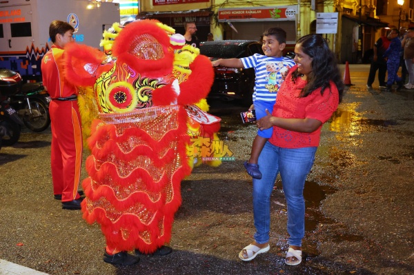 醒狮与印裔小童玩乐，场面非常有趣。