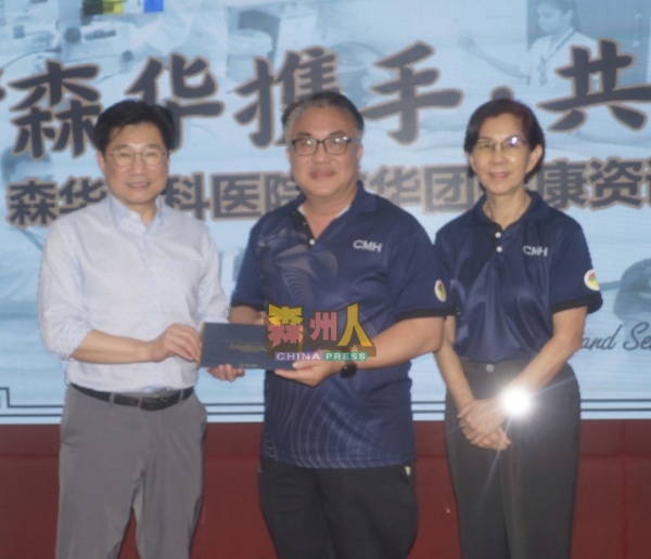邱德隆颁赠礼物给陈世标教授医生（左），右为郑瑞芝。