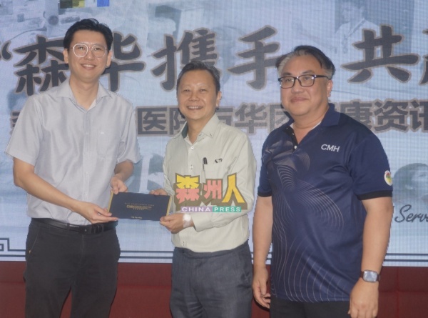 张康华颁赠礼物给吴宏发医生（左），右为邱德隆。 