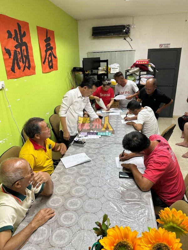 谢琪清(站者)在万茂新村民众会堂召开会议,向受影响鱼塘业者讲述协商成果。