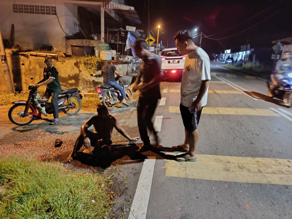 谢樟来（右）闻讯到现场，向伤者提供援助。